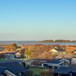 Panoramaansicht über Wohnhäuser mit Blick auf Wasser und Insel im Hintergrund.