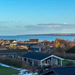 Haus mit Blick auf Meer und Küstenlandschaft. Garten und Terrasse mit Sitzmöbeln.
