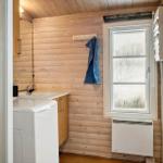 Badezimmer mit Waschmaschine, Spülung und Fenster.