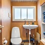 Badezimmer mit Toilette, Waschbecken und blauen Handtüchern.