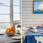 Esstisch mit blauer Tischdecke, Kaffeetassen und Brötchen. Wandbild mit Segelschiff.
