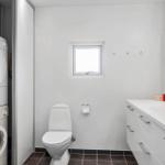 Badezimmer mit Toilette, Waschbecken und Waschmaschine
