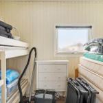 Kleines Schlafzimmer mit Doppelstockbett, Schrank und Fenster.