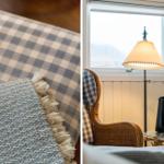 Sofa mit kariertem Kissen und grauem Deckenstoff. Lampe und Tisch vor Fenster.