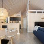 Living kitchen with dining table, sofa, and TV. Wooden walls and ceiling.