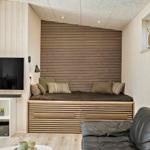 Wohnzimmer mit Schlafcouch, Fernseher und Ledersofa.