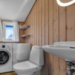 Badezimmer mit Waschmaschine, Trockner, Toilette und Waschbecken.