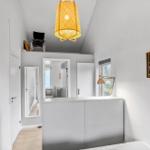 Bedroom with white walls, a ceiling lamp, and a picture on the wall.