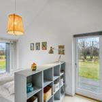 Bedroom with bed, shelving unit, and windows to outdoor terrace.