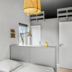 Bedroom with bed, wall art, desk, and loft bed.