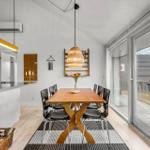 Dining room with wooden table, black chairs, and glass door to terrace.