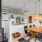 Kitchen with dining area, wooden table, chairs, and wood stove.