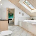 Bathroom with whirlpool, toilet, and sink. Passage to a dart room.