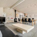 Living and dining area with wood walls, fireplace, dining table, and sofa.