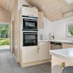 Kitchen with wood walls, built-in appliances, and view of the garden.