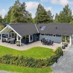 Modern villa with large garden, terrace, and grill area. Surrounded by trees and greenery.