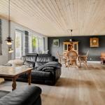 Wohn- und Essbereich mit Holzdecke, Sofa, Tisch und Stühlen.