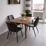 Essbereich mit Holztisch, vier Stühlen und Blick auf Balkon