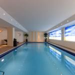 Innenpool mit blauem Wasser, Wandbildern und Sitzgelegenheiten