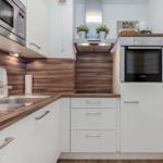 Küche mit Edelstahlgeräten, Holzoberflächen und integriertem Backofen.