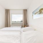 Schlafzimmer mit Doppelbett, Fenster und Wandbild