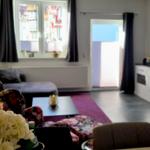 Wohnzimmer mit Sofa, Fernseher und Fenster zur Terrasse.