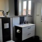 Badezimmer mit Waschbecken, Spiegelschrank und WC.