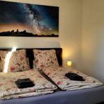 Schlafzimmer mit Bett, zwei Nachttischen und Wandbildern.