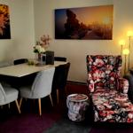 Wohn- und Essbereich mit Sitzgelegenheiten und Wandbildern.