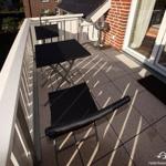 Terrace with table, two chairs, and view of house and garden