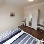 Bedroom with double bed, wardrobe, and two chairs.