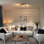 Living room with sofa, two armchairs, wooden table, and wall art.