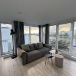 Living room with sofa, table, and water view