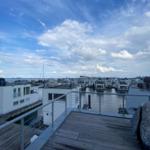 Deck with view of water and modern houses in the harbor.