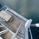 Deck with table and chairs over water, access via wooden steps.