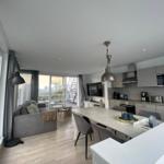 Living kitchen with dining area, sofa, and terrace view.