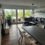 Wohn- und Essbereich mit Balkon, Sofa und Esstisch.
