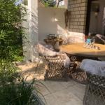 Terrasse mit runden Tisch und Stühlen, belegt mit flauschigen Decken.