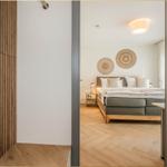 Schlafzimmer mit Bett, Nachttisch und Wanddekoration. Holzfußboden und Holzwandverkleidung.