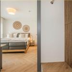 Schlafzimmer mit Bett, Nachttisch und Holzboden. An der Wand hängen zwei runde Dekorationen.