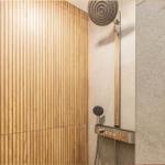 Dusche mit Holzwand und moderner Duschkopfmontage