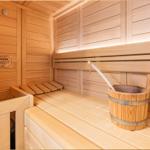 Sauna mit Holzbank, Eimer und Holzwand