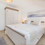 Schlafzimmer mit Doppelbett, Kleiderschrank und Nachttisch mit Lampe.