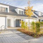 Moderne Reihenhaus mit Terrasse und Gartenbereich im Herbst.