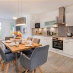 Moderne Küche mit Esstisch und Sitzgelegenheiten. Durchgang zur Terrasse.