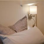 Bettkopf mit Wandlampe und Kissen