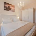 Schlafzimmer mit Doppelbett, Kleiderschrank und Deckenventilator.