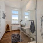 Badezimmer mit Dusche, Waschbecken und Fenster mit Blick.