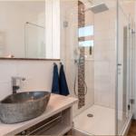 Bad mit Dusche, Waschbecken und Handtuchhalter