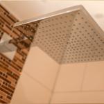 Duschkopf mit Regendusche und Ziegelwand im Badezimmer
